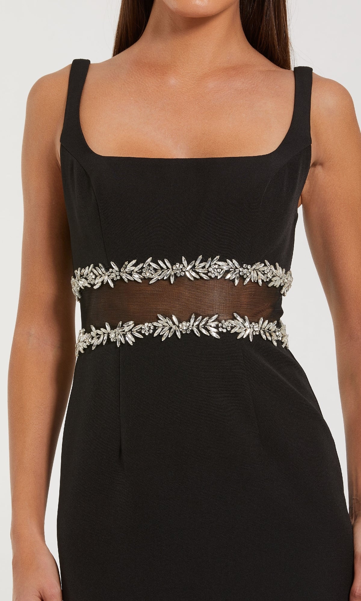 Close-up of the bodice on a black dress a woman is modeling on a white background.
